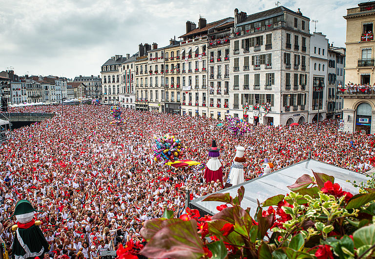 Une marée humaine rouge et blanche déferle sur la place de l'hôtel de ville le jour de l'ouverture des Fêtes.